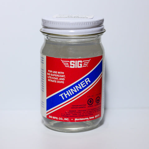 Small blue and red glass jar of SIG Thinner